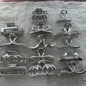 Collection of 12 silver metal hair claw clips in various geometric and bow-knot designs