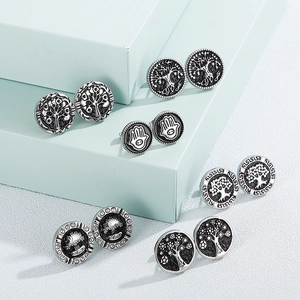 Collection of vintage silver-tone bohemian stud earrings featuring Tree of Life and Hamsa designs