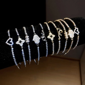 Selection of zircon-encrusted heart and clover charms on gold and silver chain bracelets