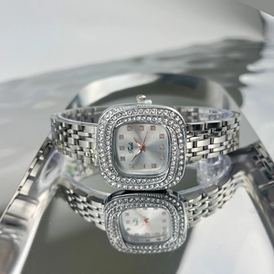Macro shot of silver square watch face with diamond-set bezel and metal chain strap