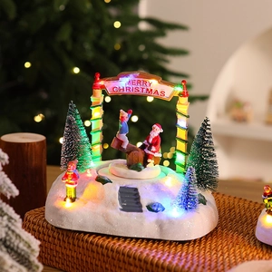 Détail d'une maison de Noël en résine avec éclairage LED et figurines animées