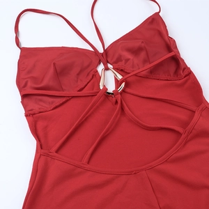 Detail of red backless dress with a gold metal ring and crisscross strap design