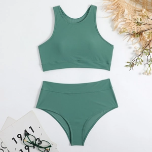 Flat lay of high-waisted dark green two-piece swimsuit with summer vacation accessories