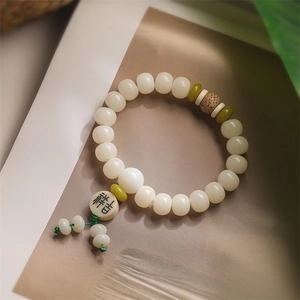 Macro detail of white Bodhi seed prayer beads with green spacer and Jixiang carving