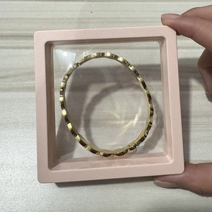 Golden wavy edge bracelet showcased inside a pink square PE film suspension box