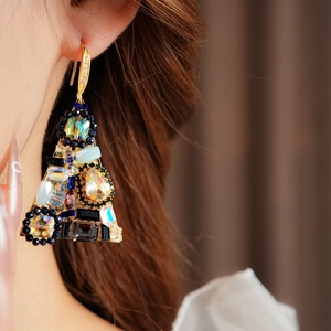 Close-up of vintage triangle drop earring with colorful crystals and gold metal hook