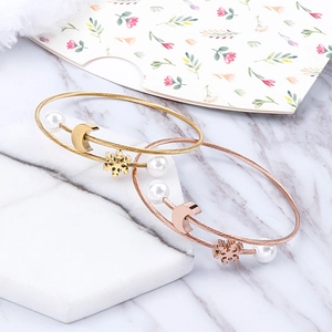Dual-tone stainless steel cable bracelets featuring moon, snowflake charms and pearls