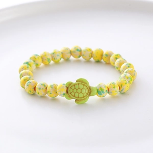 Macro shot of turquoise beads and a green turtle pendant on a handmade bracelet