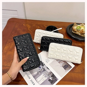 Detailed view of quilted leather long wallets in black and beige with gold zippers