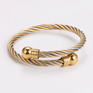 Macro detail of bicolored spiral twisted steel bangle with metallic ball ends
