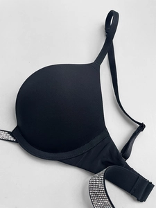 Close-up of black push-up bra featuring shiny rhinestone-embellished shoulder straps