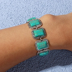 Detail showing vintage turquoise stone bracelet on wrist with embossed silver frame