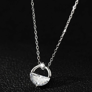 Elegant silver necklace with a semi-circular clear zircon pendant on a black texture