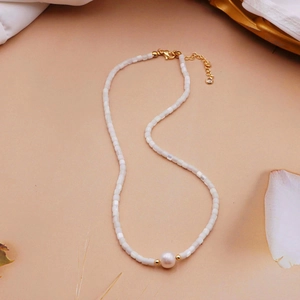 Detailed macro view of white square beads and large round pearl on a 14K gold-plated chain