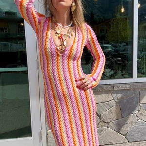 Detail of colorful wave pattern knit dress with deep V-neck and slim long sleeves