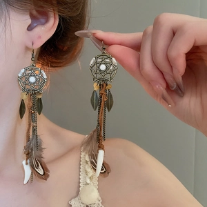 Detail of bohemian dreamcatcher earrings with feathers and beads on model