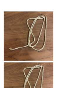 Macro detail of multi-layered pearl necklace with golden heart pendant on wood