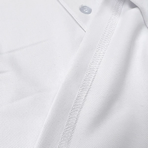 Close-up of white piqué polo shirt fabric with transparent snap buttons and stitching