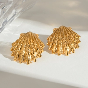 Golden starfish stud earrings with textured shell finish on a crystal background