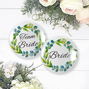 Floral Team Bride and Bride badges on white wood with elegant wedding flower decoration