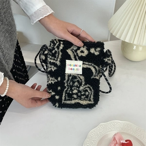 Detail of plush black and white patterned crossbody bag with soft faux fur texture