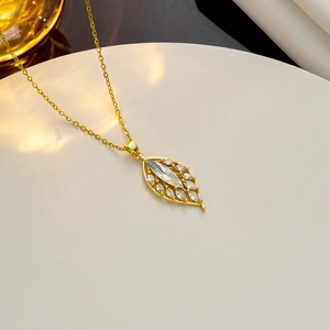 Detailed close-up of a golden leaf pendant necklace featuring marquise-cut clear zircons