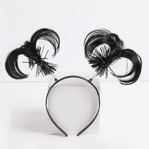 Detail view of the black plastic headband featuring synthetic fiber wing-like feathers