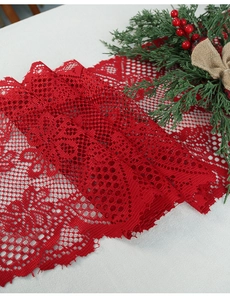 Close-up of red lace Christmas table runner with intricate floral hollow patterns