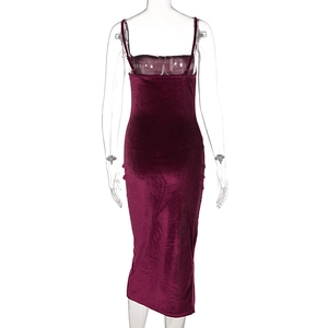 Detail view of the back of a burgundy velvet midi dress featuring a slim fit and high slit