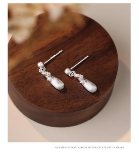 Macro detail of S925 sterling silver stamp on water drop shaped earrings