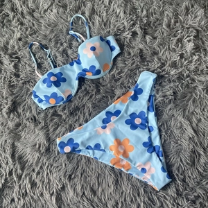 Detail of floral print bikini set with underwire cups and adjustable straps on plush surface