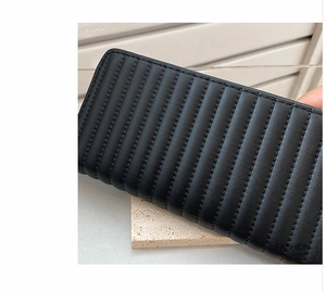 Detailed view of the black PU leather wallet with vertical quilted pattern and stitching