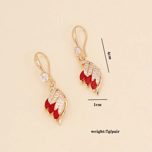 Detailed view of gold feather earrings with red zircon and size markings 4cm by 1cm