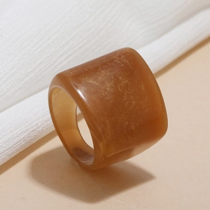 Macro detail of amber resin ring with sparkling gold foil flakes and smooth finish