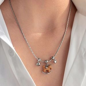 Collier argenté avec cheval à bascule en bois, clochette et pendentif cœur sur modèle