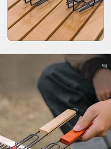 Detail of long wooden handle on black metal BBQ grilling basket for heat protection