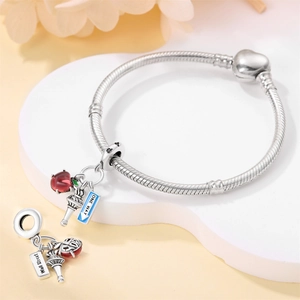 Macro shot of silver snake chain bracelet with heart clasp and New York themed charms