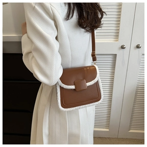 Détail du sac à main marron avec bordure en peau de mouton blanche et boucle carrée