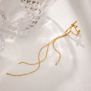 Gold stainless steel cross ear cuff with dangling tassel chains on a white background