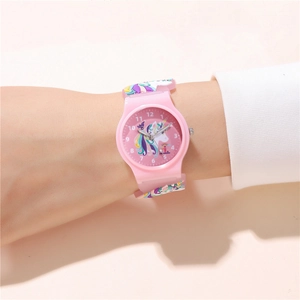 Detailed view of pink unicorn kids watch with embossed strap on a child's wrist