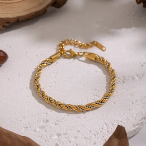 Vue macro d'un bracelet en chaîne torsadée bicolore avec finition dorée et argentée et fermoir