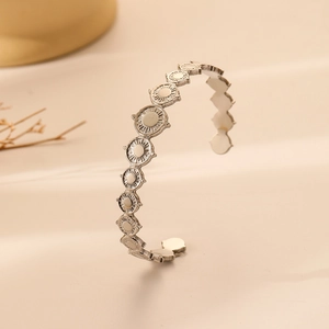 Detail of silver open bangle with continuous circular sun patterns and metallic luster