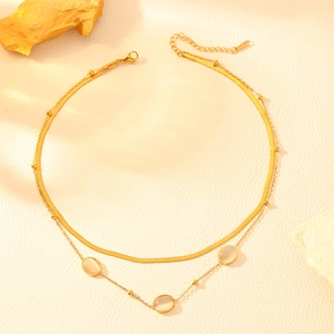Detail of double-layer gold snake chain necklace with three oval cat-eye opal stones