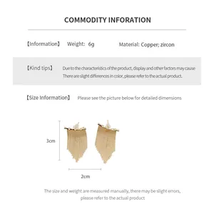 Vue détaillée des boucles d'oreilles pompon plaquées or 14K de 3 cm de haut et 2 cm de large