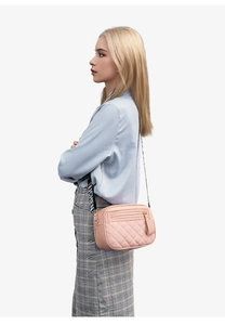 Pink quilted camera bag with love-letter wide strap worn by a female model