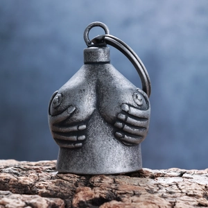 Vintage silver double skull bell pendant made of alloy on a rustic wood surface