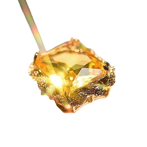 Exaggerated gold-plated ring featuring a large champagne square gemstone and clear accents