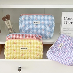 Detailed view of quilted plaid makeup bags with cute bows in blue, yellow, and purple