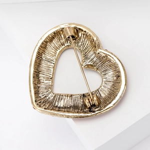 Elegant vintage golden heart brooch with red stones and back pin detail shown on white background