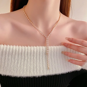 Close-up of golden Y-shaped necklace featuring sparkling zircon water drop tassels